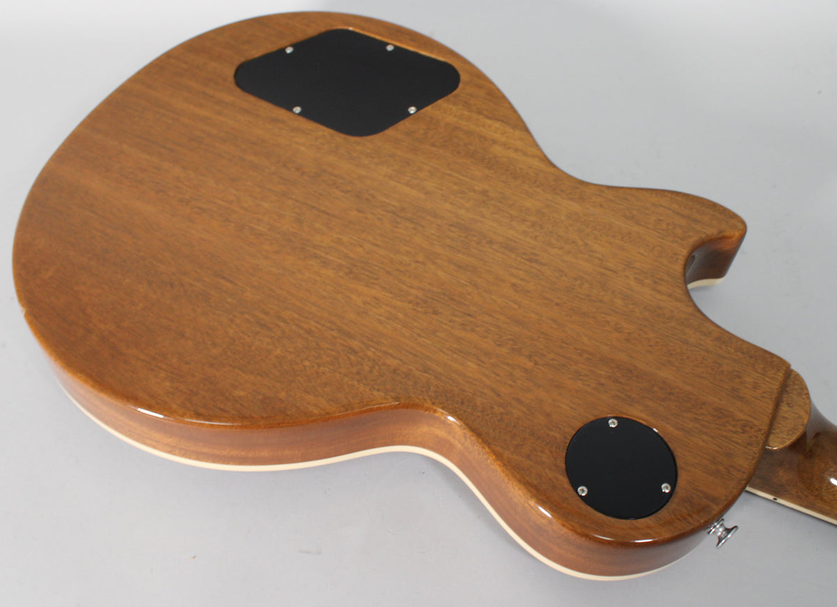 The guitar's back, a glossy medium brown with visible wood grain, features two black control cavity covers and cream binding.