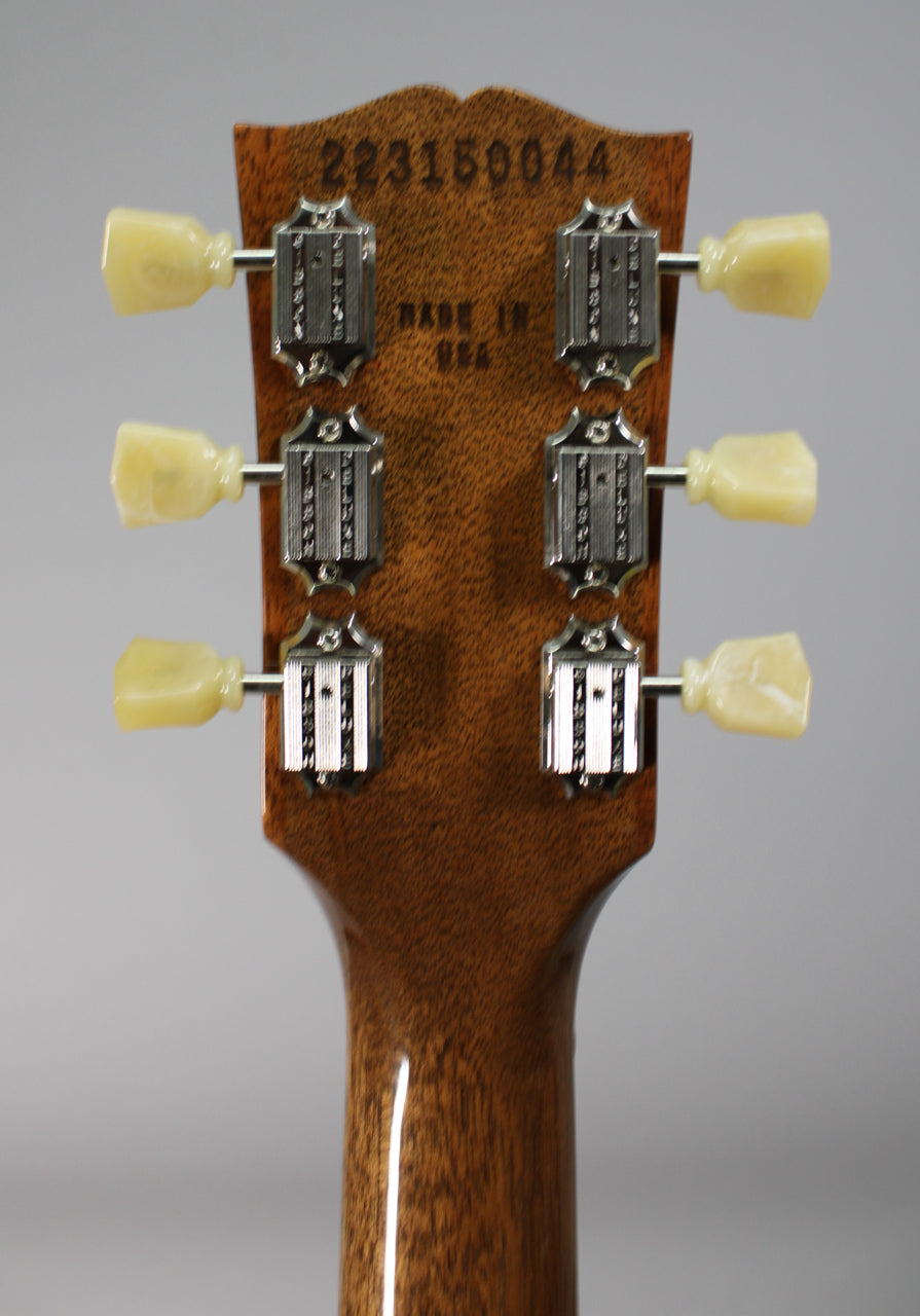 Rear view of the headstock and upper neck, showing six cream-colored tuning pegs and chrome tuners on a dark wood finish.