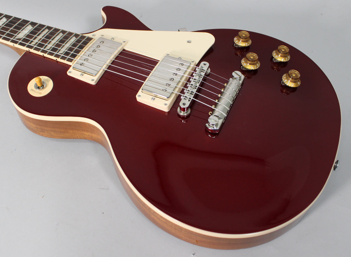 Sparkling burgundy Les Paul body, angled from the neck, showing cream binding, humbuckers, and gold top hat knobs.