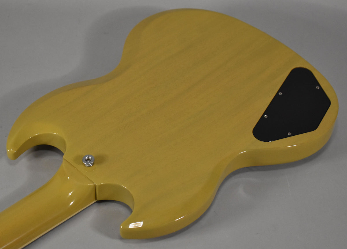The back of a glossy TV yellow SG guitar, showing the neck joint, strap button, and a black control cavity cover.