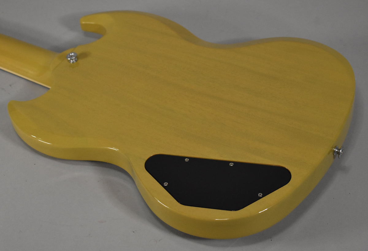 The back of a TV yellow SG, showing the grain through the finish, with a black control cavity cover.