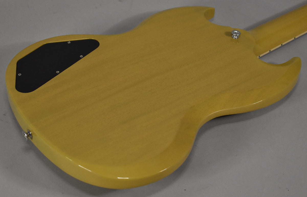 The back of a TV yellow SG body, showing a black control cavity cover, two chrome strap buttons, and the neck joint.