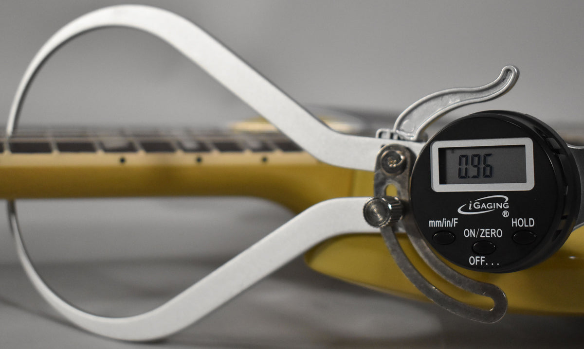 A digital caliper measures the fret height of the TV Yellow guitar's neck, displaying "0.96" on its screen.