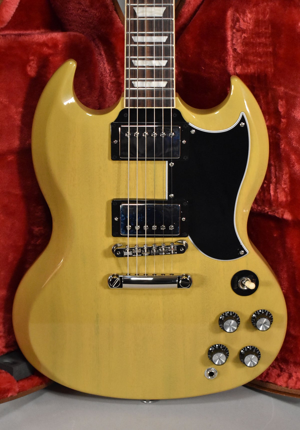Full-frame, top-down view of a TV Yellow SG with a black pickguard, chrome hardware, and trapezoid inlays.