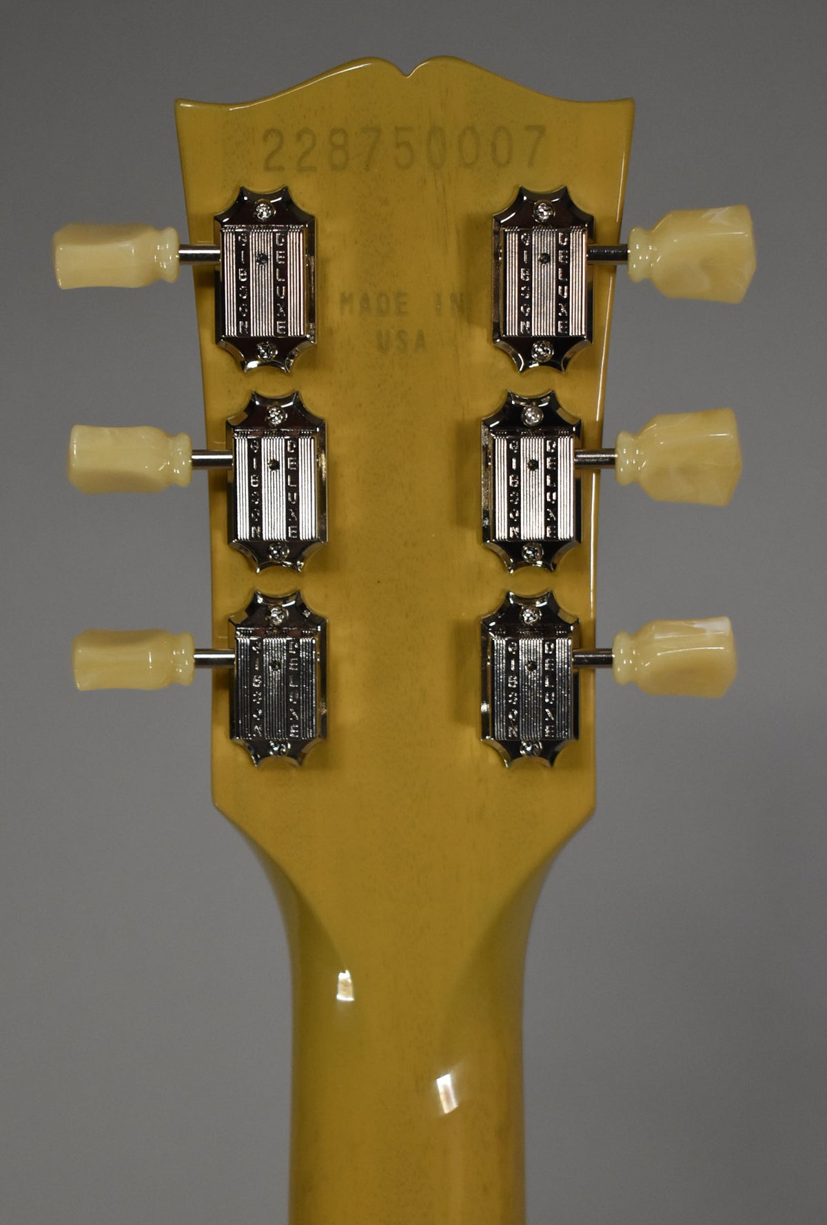 The back of a TV Yellow headstock with six chrome tuners and cream plastic buttons, showing a serial number.