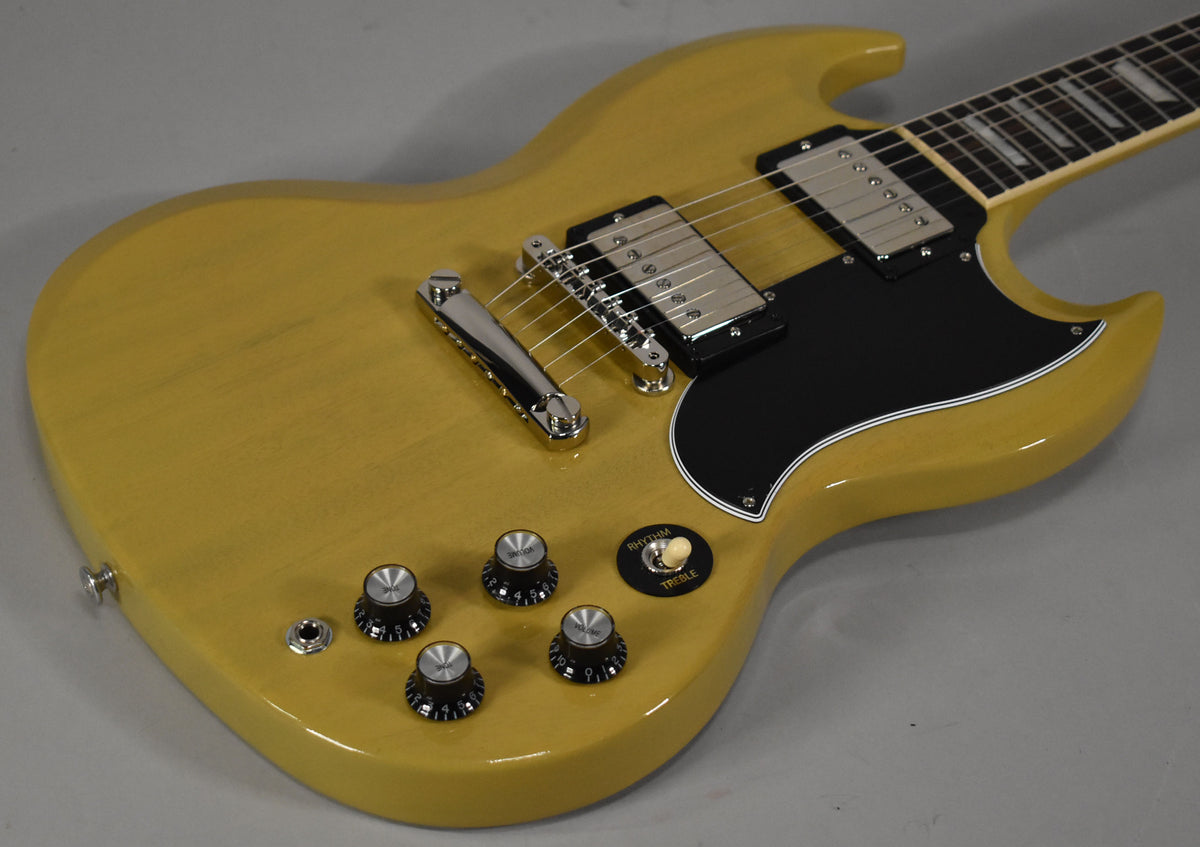 The TV Yellow SG body is angled from the lower left, showing its black pickguard, chrome hardware, and four black control knobs.