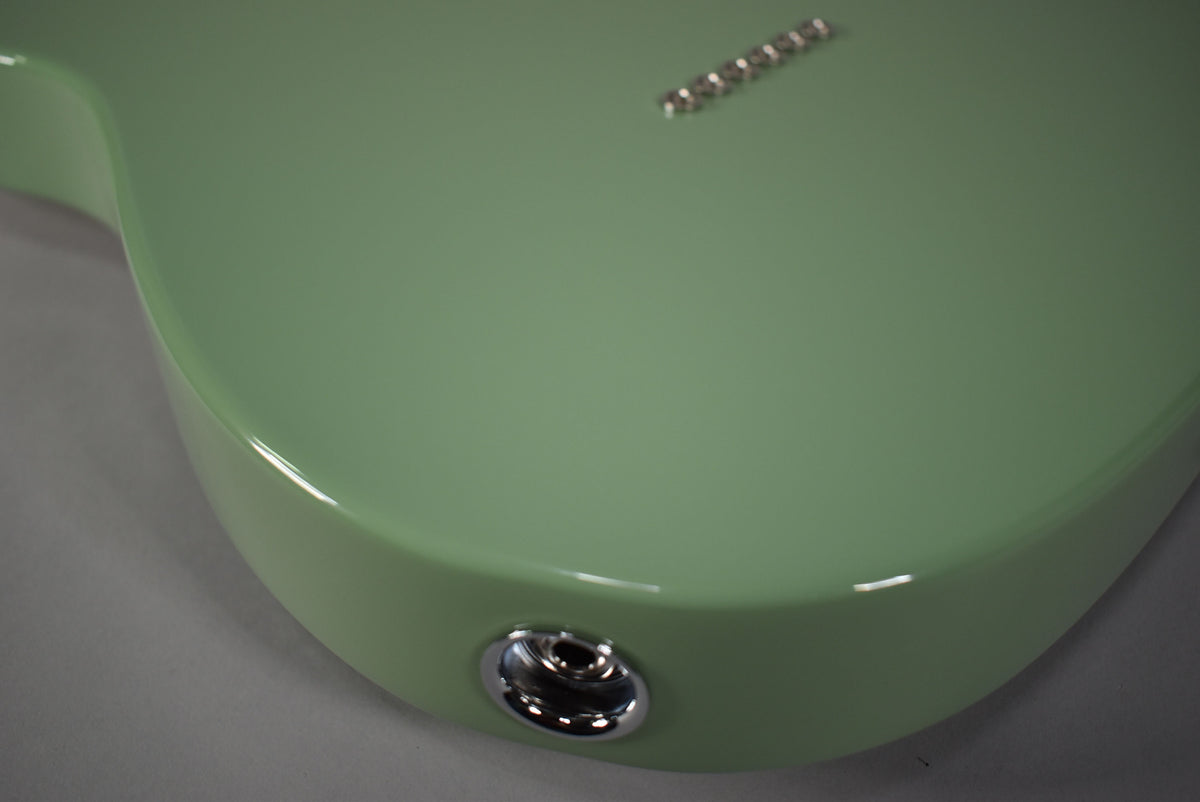 Close-up of the Telecaster's lower bout in Birch Green, showing the chrome output jack and six string ferrules on the back.