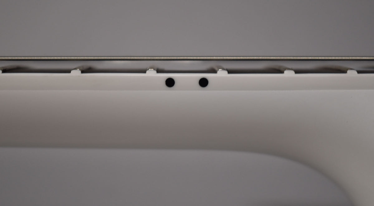 Close-up of the Alpine White Les Paul's neck, showing the side dots and the top of the frets and strings against a gray background.