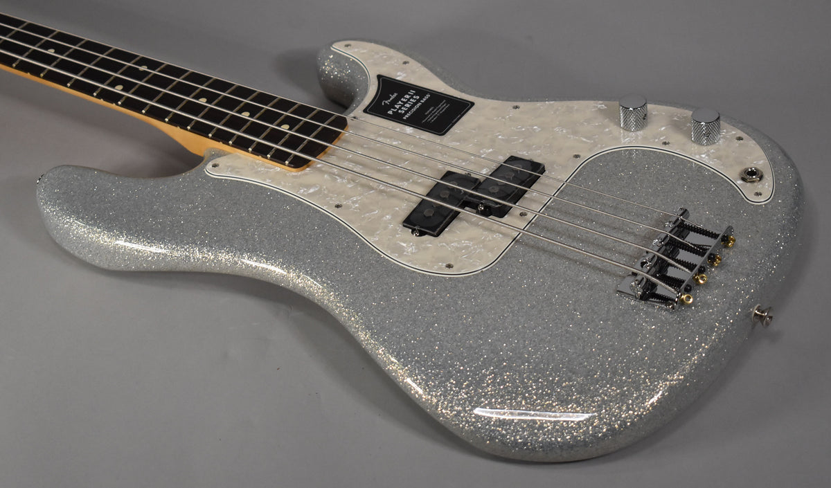 Silver sparkle bass, angled from the neck to the lower bout, with a pearloid pickguard, split pickup, and chrome hardware.