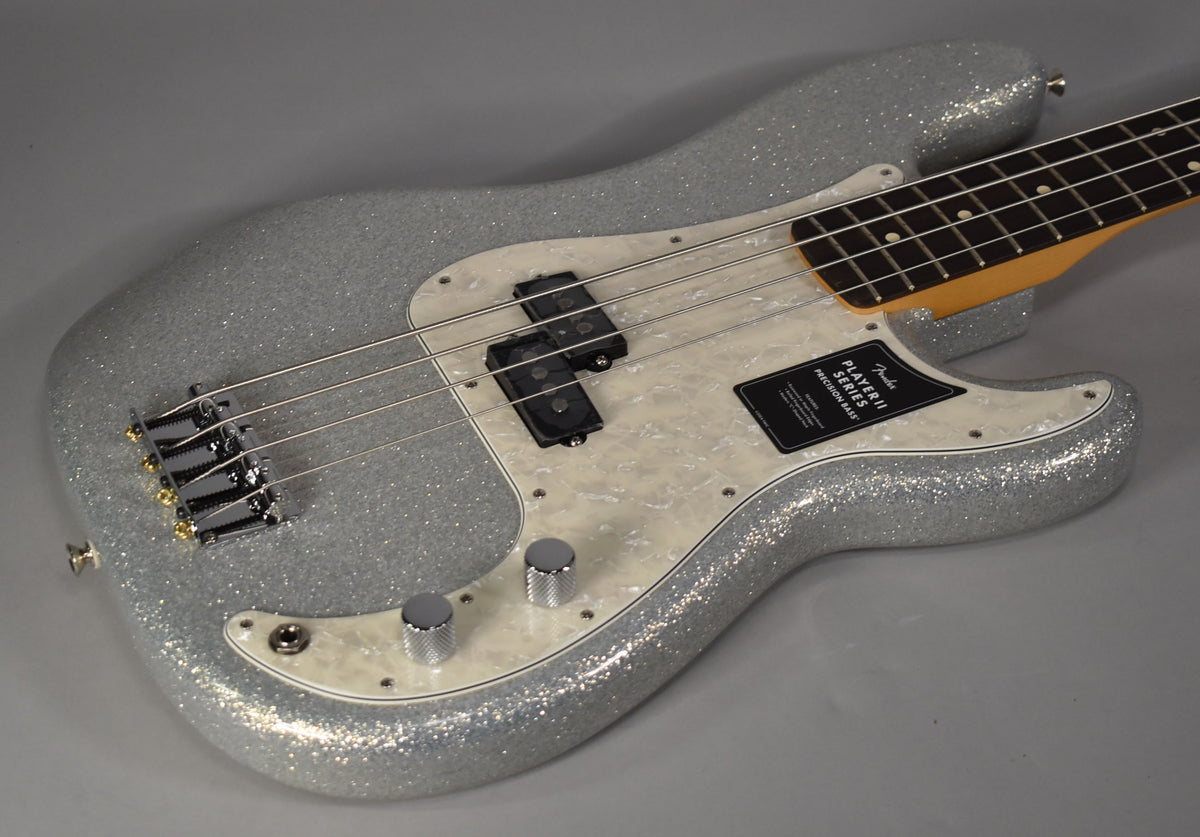 Silver sparkle bass, angled from above, showing the body, pearloid pickguard, split pickup, and chrome controls.
