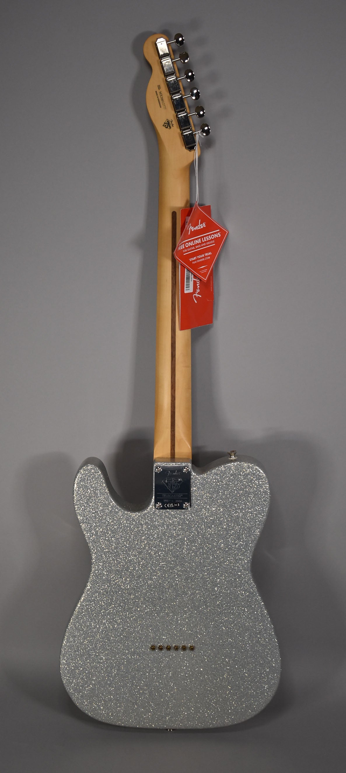The back of a silver sparkle Telecaster, showing the maple neck, chrome tuners, and string-through-body ferrules.