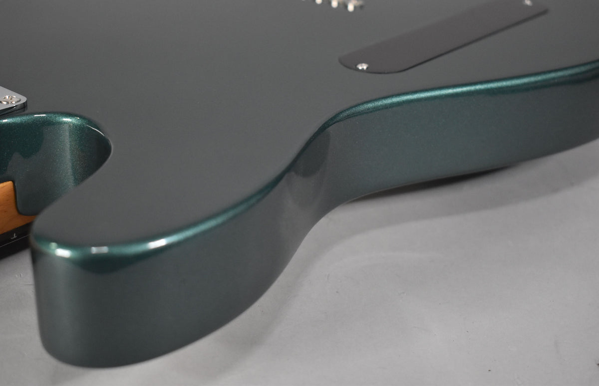 Close-up of the guitar's lower bout, showing the Sherwood Green metallic finish and a black control plate on the back.