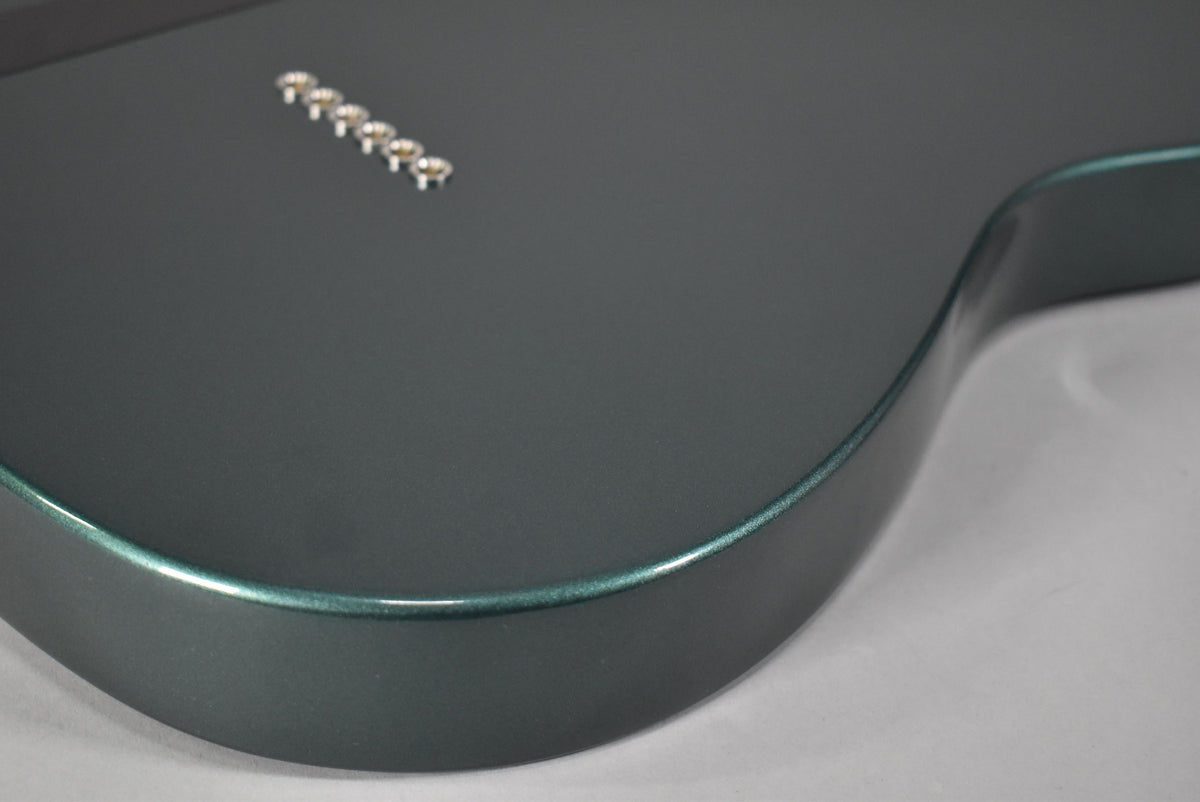 Close-up of the guitar's Sherwood Green body, showing the metallic finish and six string ferrules on the back.