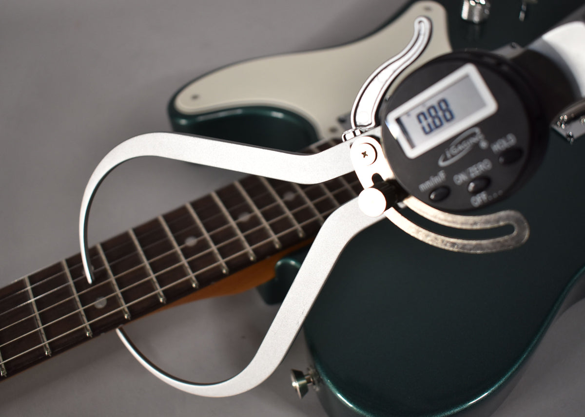 A digital caliper measures the dark rosewood fretboard of the Sherwood Green Telecaster, showing 0.88 on its screen.