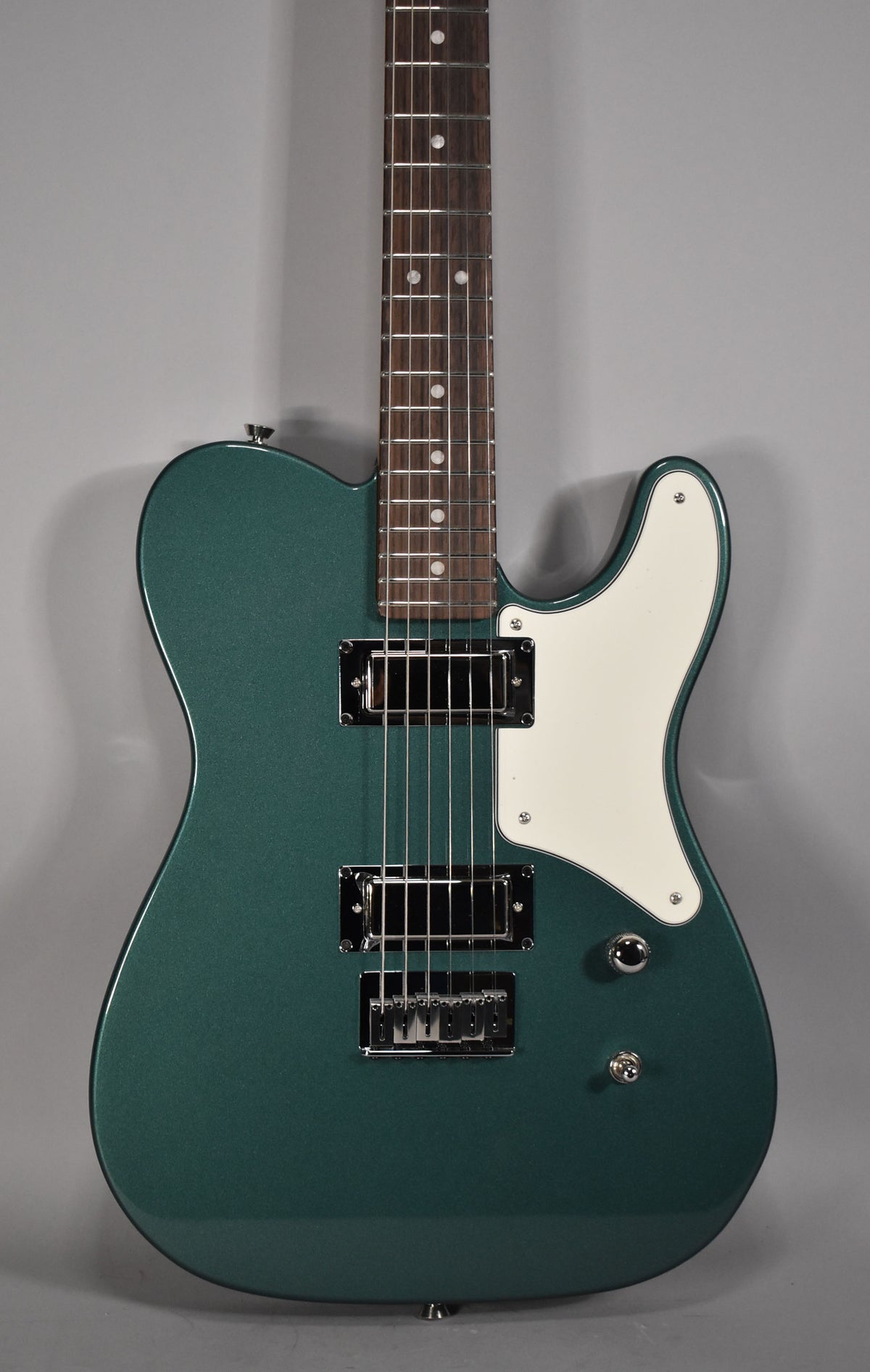 Full-frame view of a metallic Sherwood Green Telecaster with a white pickguard, two chrome humbuckers, and a rosewood fretboard.