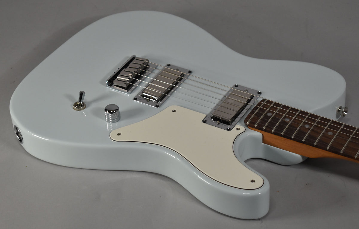 Light blue solid-body electric guitar, angled from above, showing the body, cream pickguard, two chrome humbuckers, and a single chrome knob.