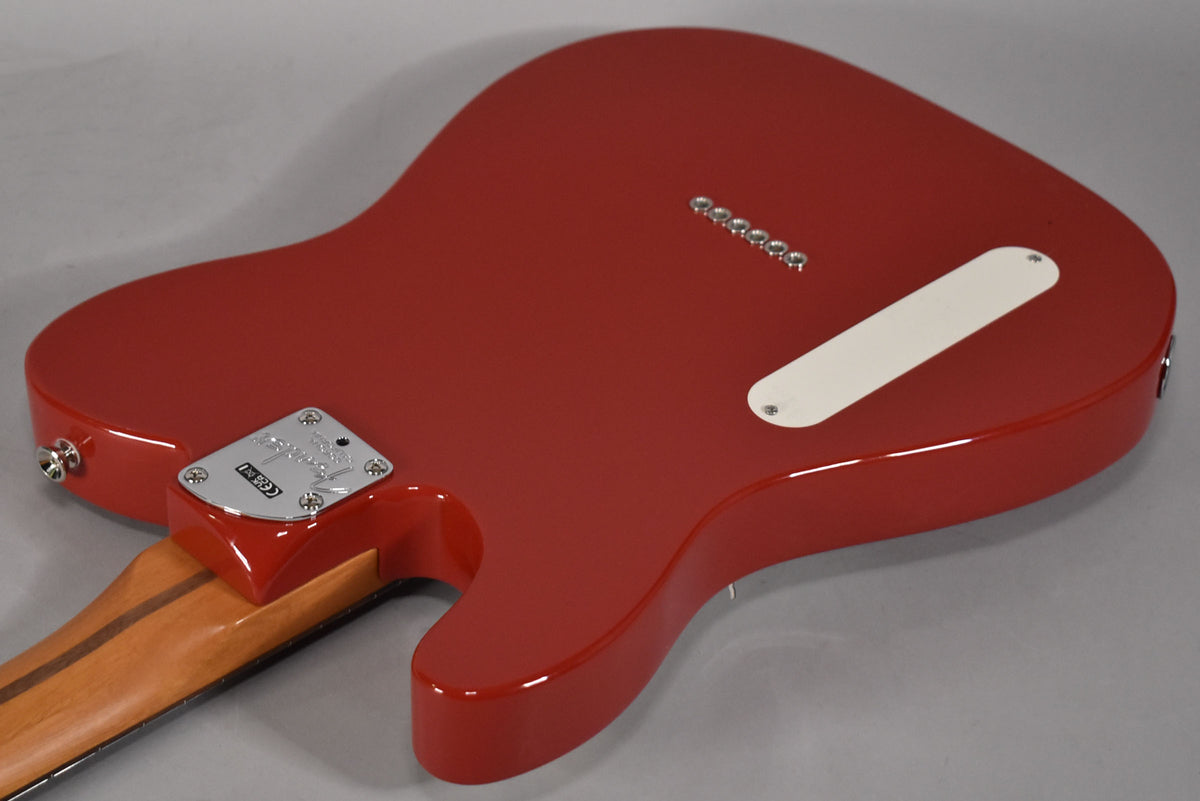 The back of a glossy red Telecaster, angled from the lower bout, shows a chrome neck plate, string-through ferrules, and a white control plate.
