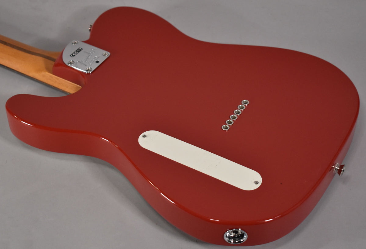 The back of a glossy red Telecaster body, angled from the neck joint to the output jack, with a white control plate.