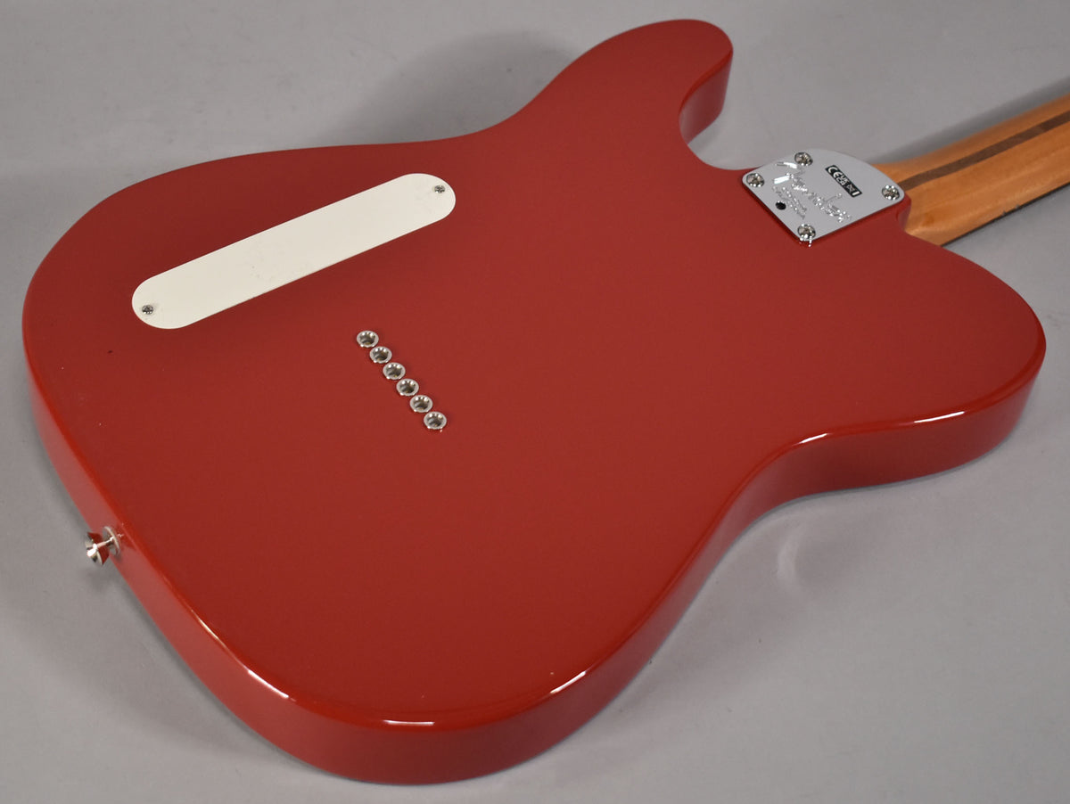 The back of a glossy red Telecaster body, showing a white control plate, six string ferrules, and a chrome neck plate.