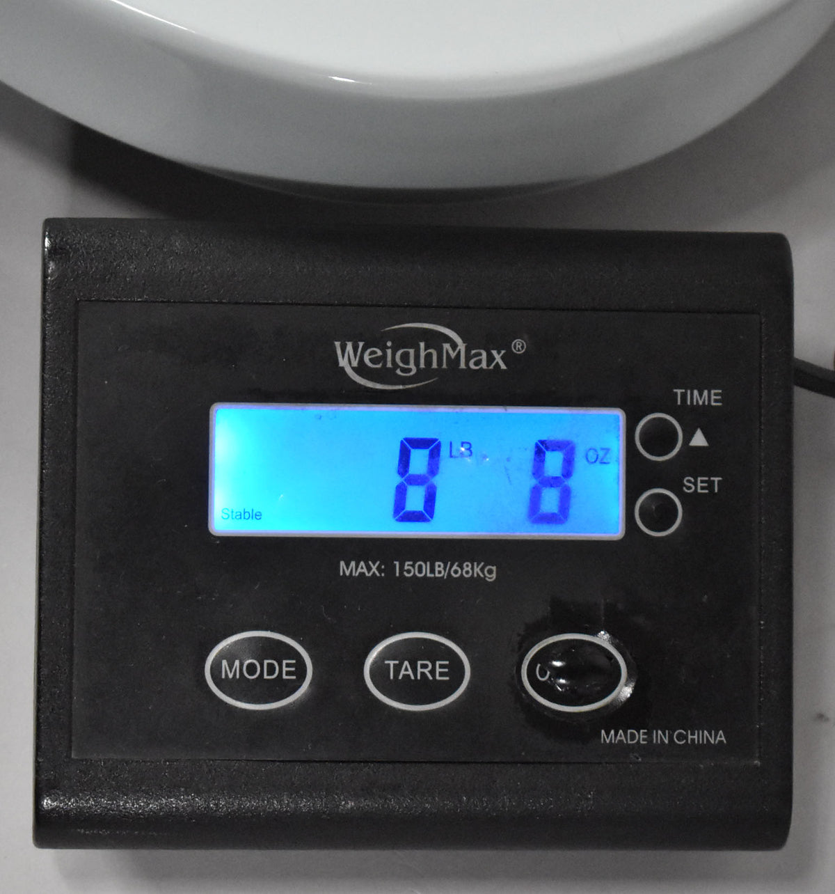 A black digital scale displays "8 LB 8 OZ" on a bright blue screen, with "Stable" visible in the corner.