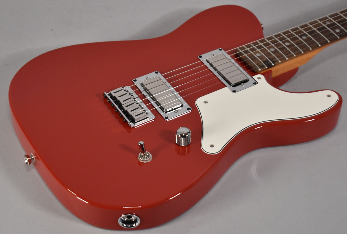 The glossy red electric guitar is angled from the upper left, showing its body, white pickguard, two chrome humbuckers, and bridge.