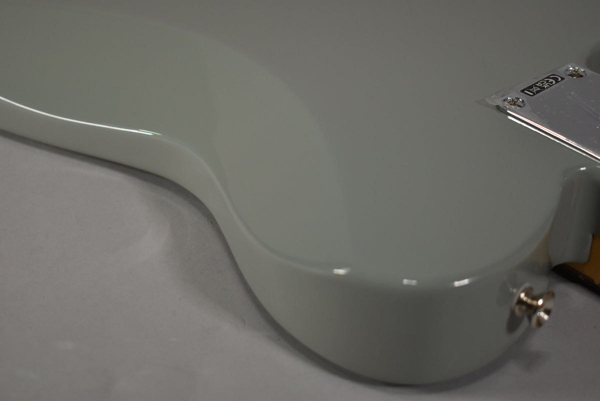 Close-up of the guitar's lower bout and output jack, showing the glossy Cactus Gray finish and a chrome neck plate.