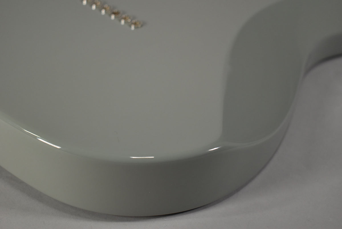 Close-up of the Telecaster's lower bout, showing the smooth, glossy Cactus Gray finish and six chrome string ferrules on the back.