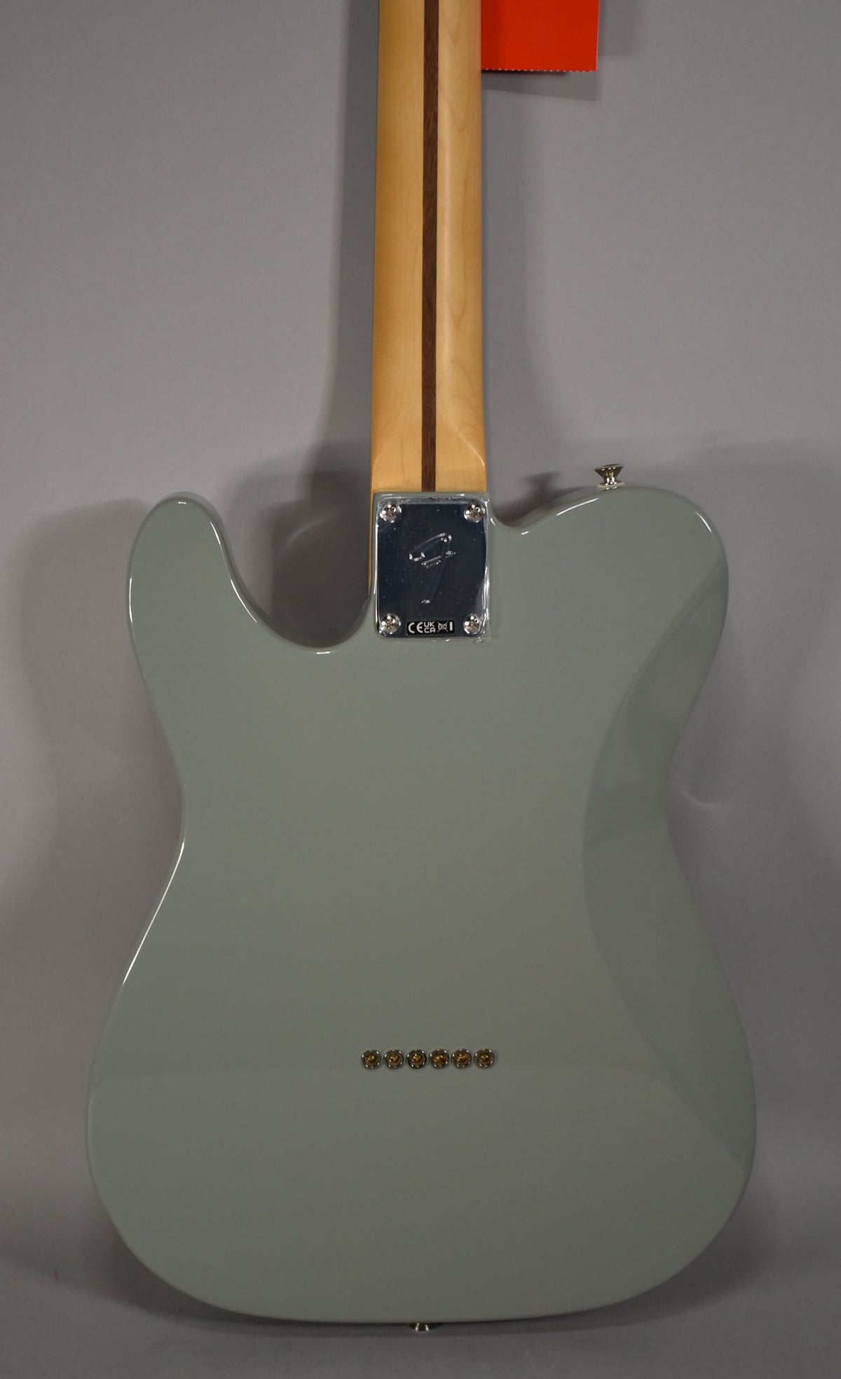 The back of a glossy Cactus Gray Telecaster, showing the light wood neck, chrome neck plate, and six string ferrules.