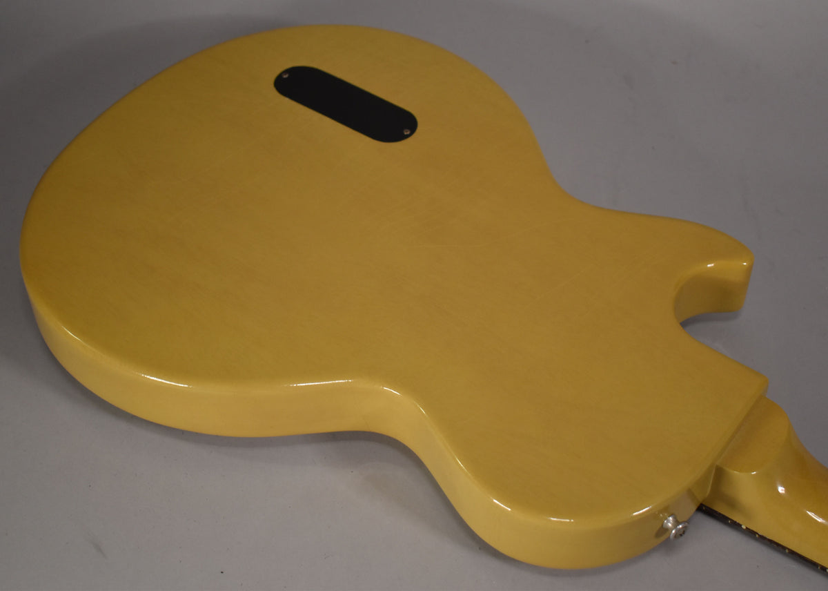 The back of the TV Yellow guitar body is angled, showing a black control cavity cover and a chrome strap button.