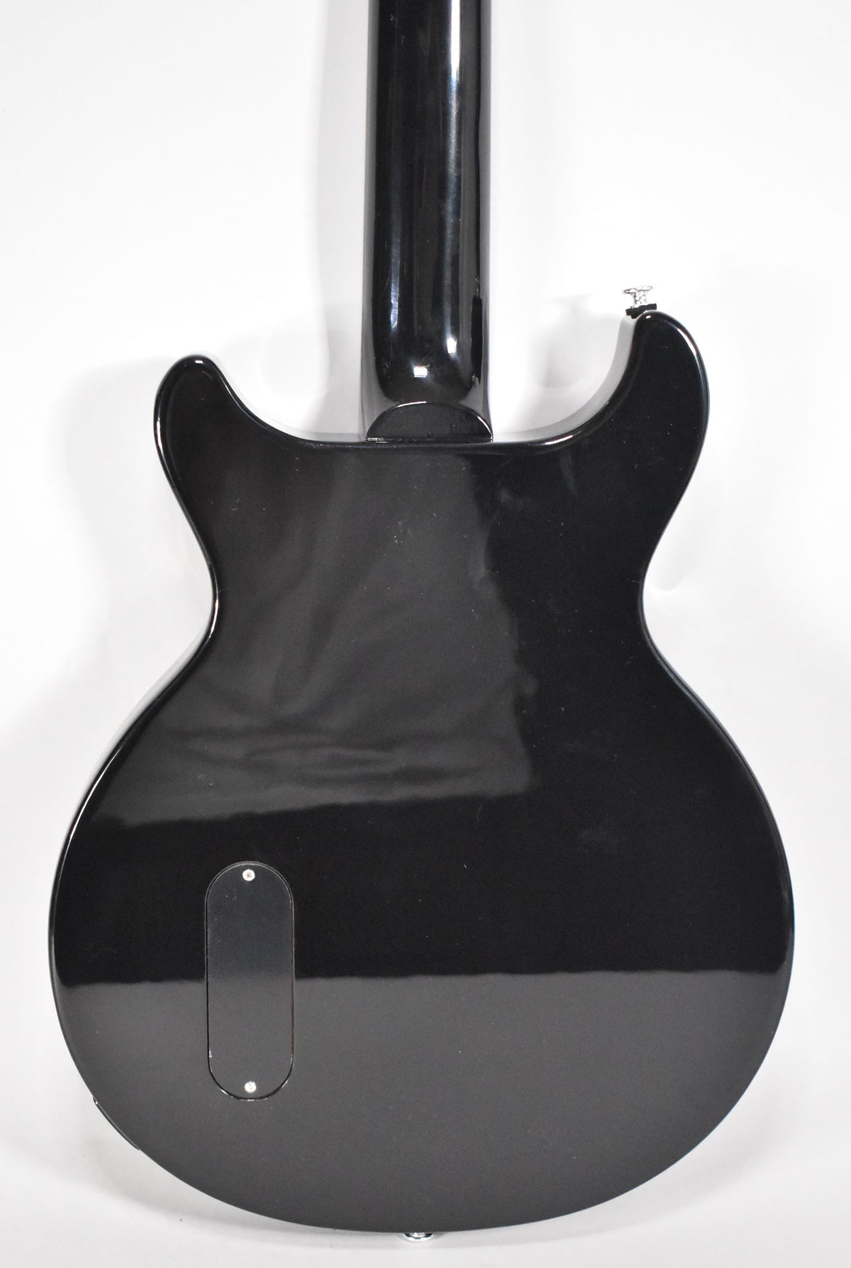 The back of the glossy ebony double-cut guitar shows a control cavity cover and a strap button at the bottom edge.