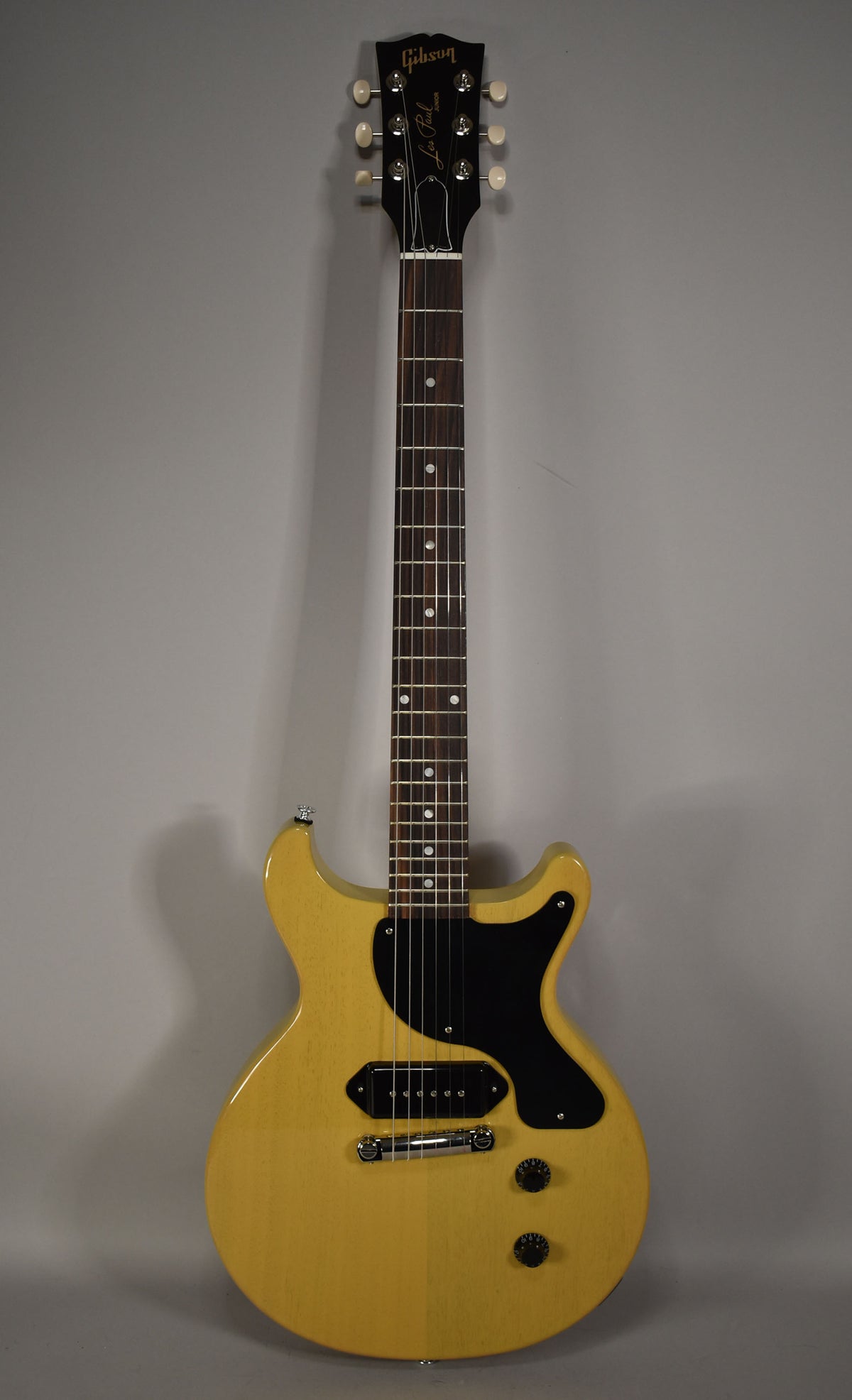 Full-length view of a TV Yellow double-cutaway electric guitar with a black pickguard, single P90 pickup, and two black control knobs.