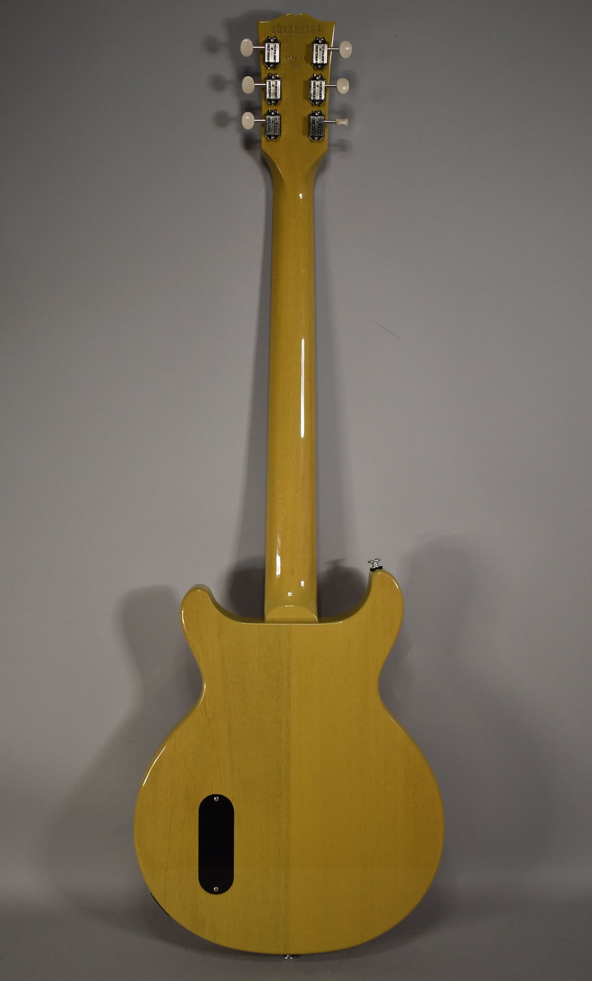 Full rear view of a TV Yellow double-cut guitar with a glossy finish, showing the neck, headstock with 6 tuners, and control cavity cover.
