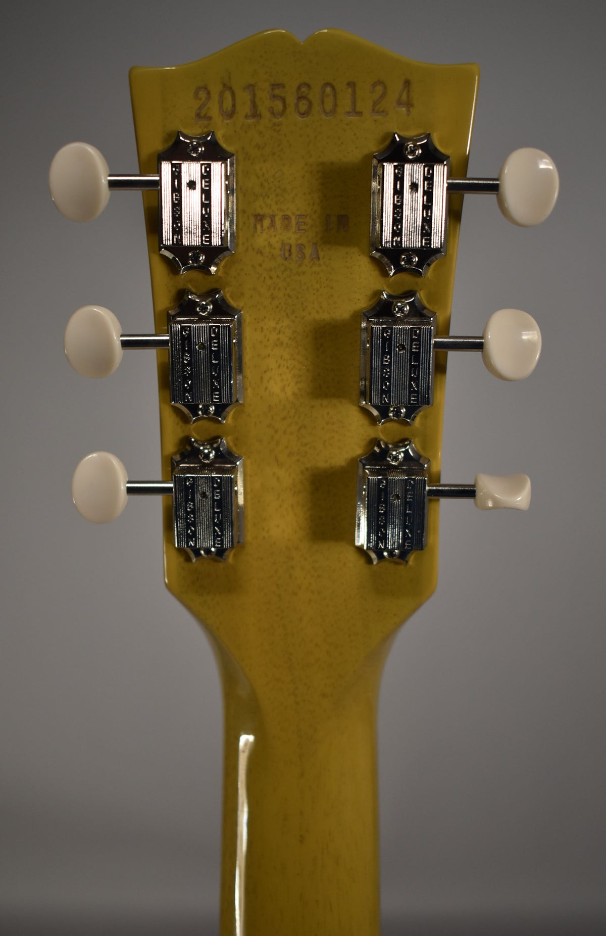 Rear view of a TV Yellow headstock and neck, showing six chrome tuners with cream buttons and light finish checking.