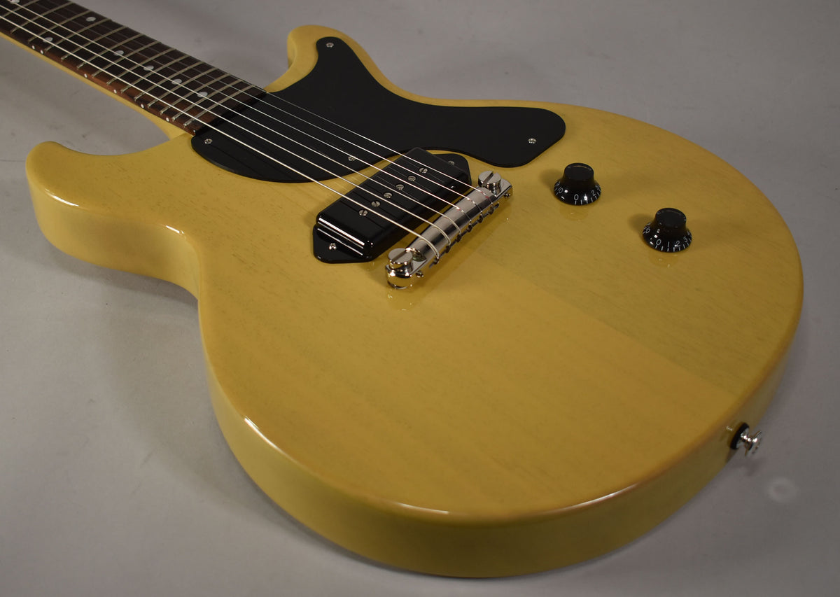 The TV Yellow double-cutaway electric guitar is angled from the upper left, showing the black pickguard, P90 pickup, and two black control knobs.