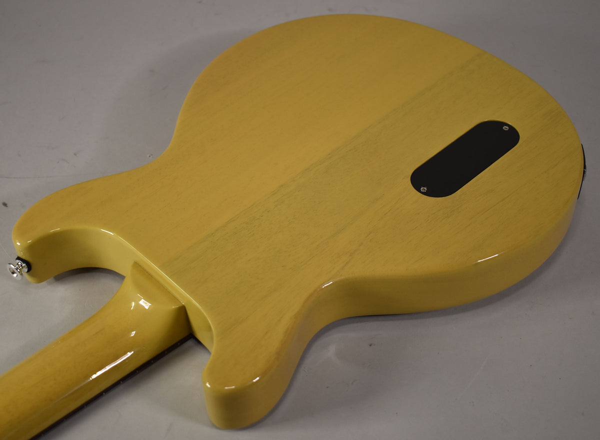The back of the TV Yellow guitar body and neck, showing a black control cavity cover and a chrome strap button.