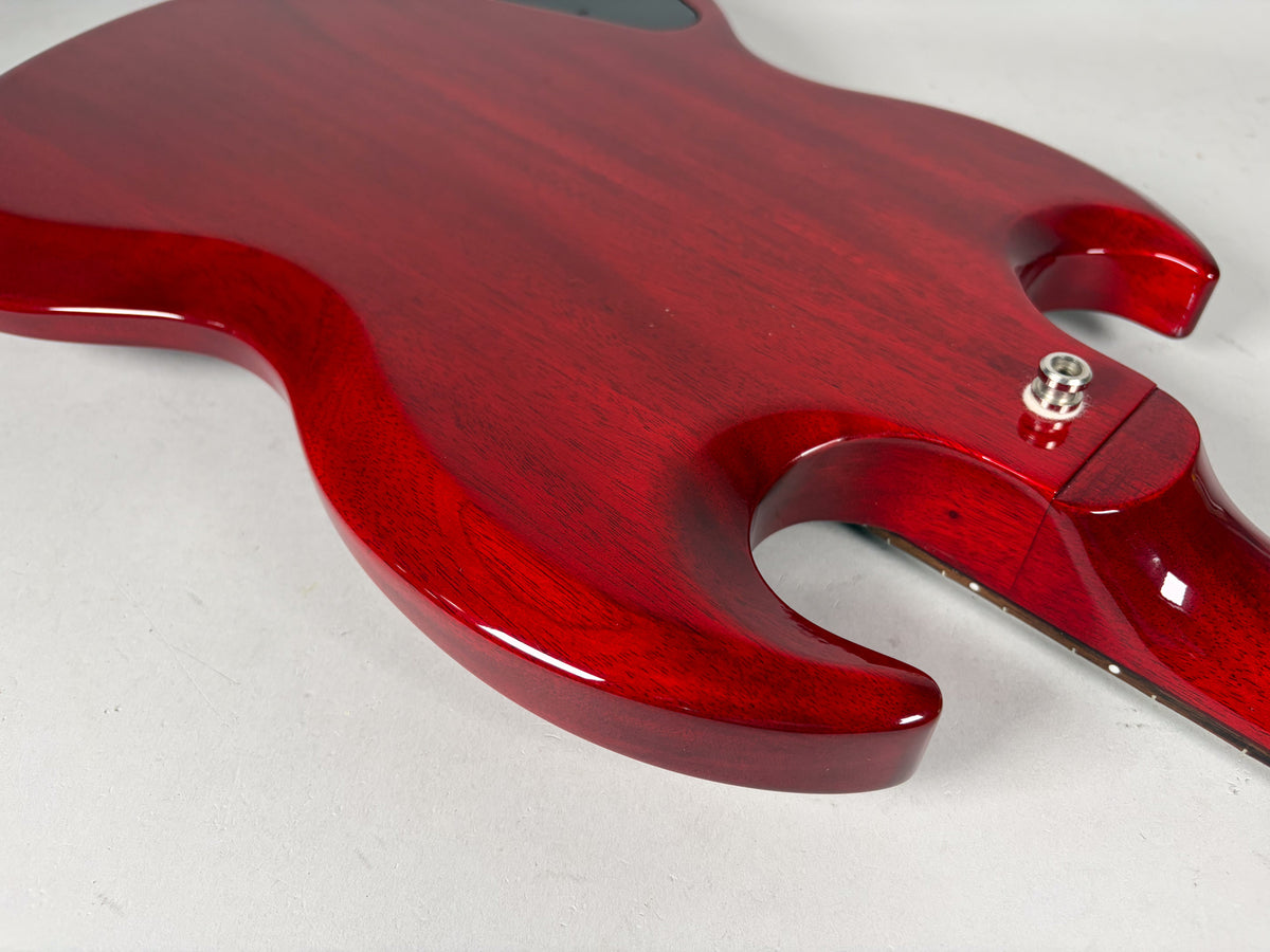 The back of the cherry red SG bass body, showing the lower horn and neck joint with a chrome strap button.