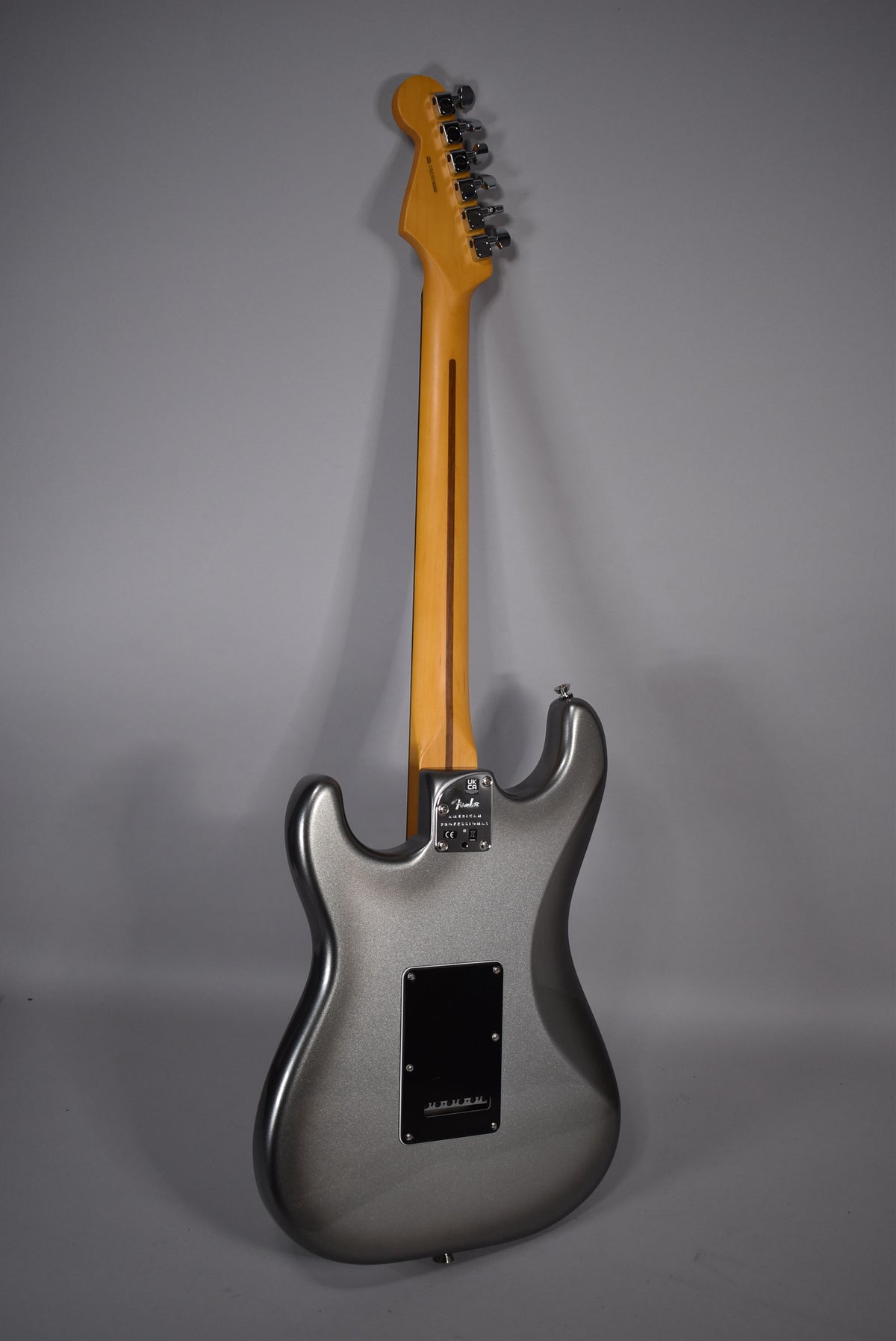 Full rear view of a metallic gray Stratocaster with a light maple neck, chrome tuners, and a black tremolo cover.