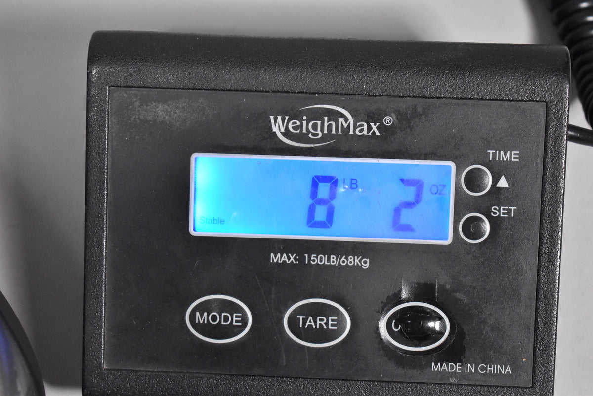 Close-up of a black digital scale displaying "8 LB. 2 OZ." in bright blue text, with "Stable" lit on the left.