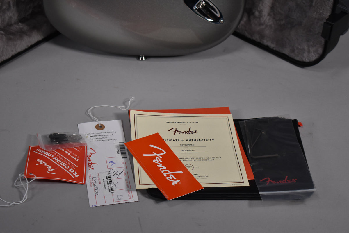 Close-up of the guitar's Mercury finish body and chrome strap button, with a certificate of authenticity and other paperwork.