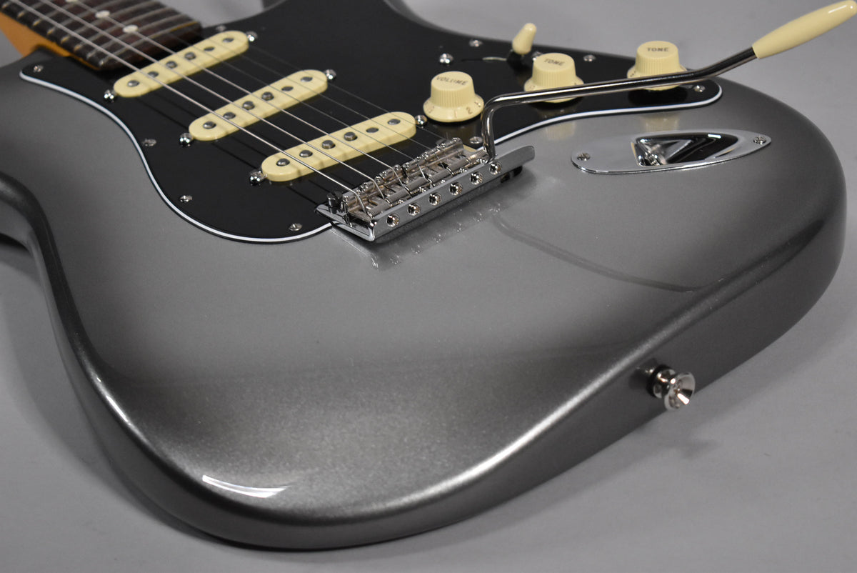 The upper body of a metallic gray Stratocaster, with a black pickguard, cream pickups, and chrome hardware.