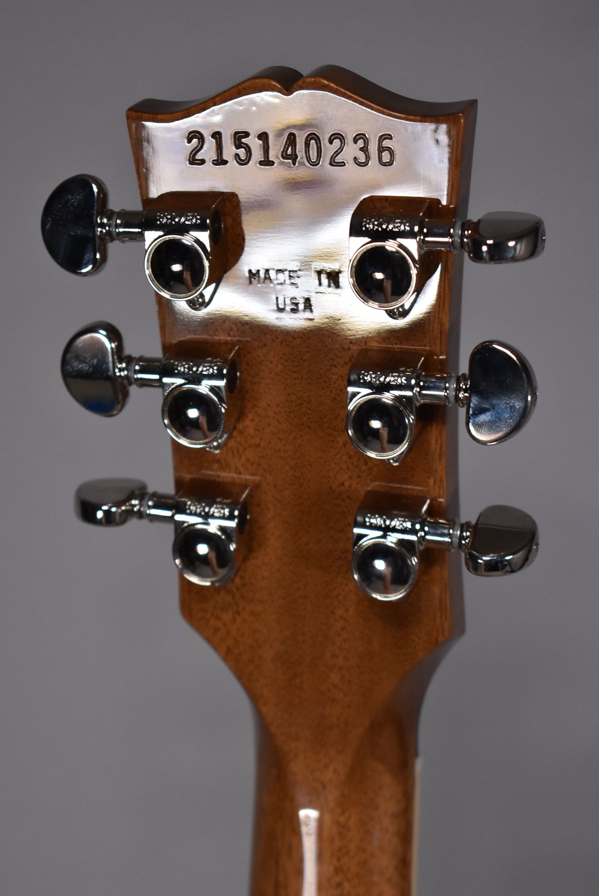 The back of the headstock and upper neck, showing six chrome tuners, a serial number, and "MADE IN USA" stamped into the wood.