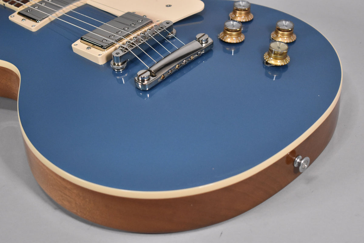 Close-up of the Pelham Blue guitar body, showing the bridge, neck pickup, four gold top hat knobs, and cream binding.