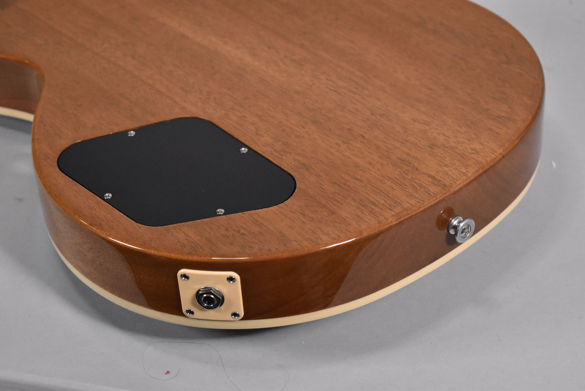 The guitar's back shows a mahogany finish, a black control cavity cover, a cream output jack plate, and a chrome strap button.