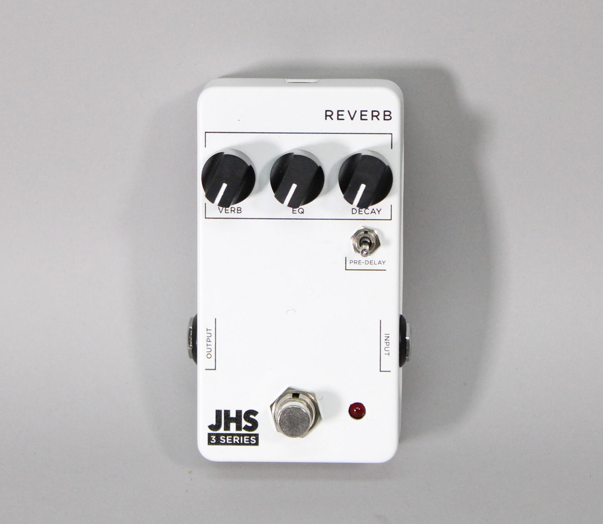 Top-down view of a white reverb pedal with three black knobs labeled "VERB," "EQ," and "DECAY," plus a small toggle switch.