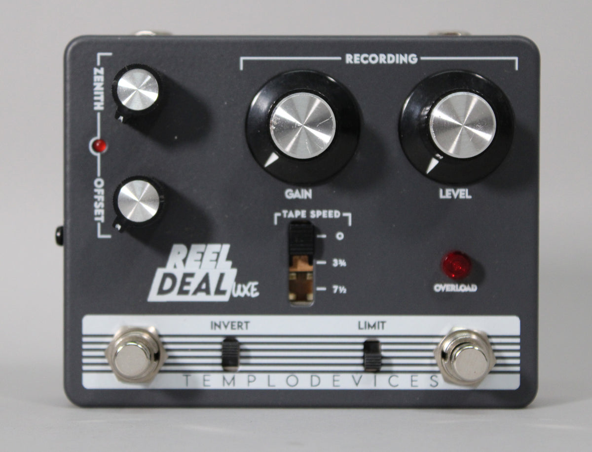 A dark gray pedal with two large black knobs, two smaller silver knobs, a three-position toggle switch, and two footswitches.