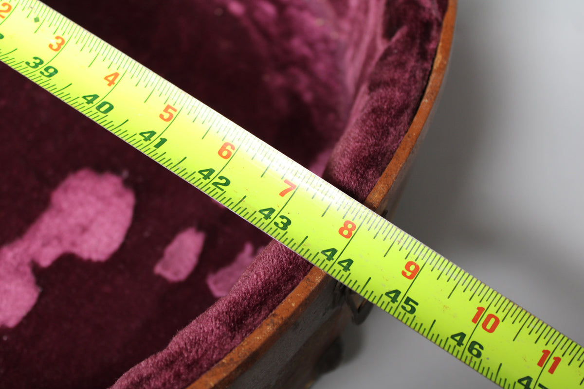 A yellow tape measure extends diagonally across the case's pink velvet interior, showing measurements from 39 to 47 inches.