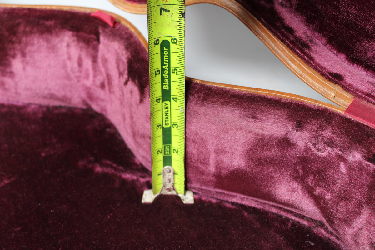 A tape measure shows a depth of 6.5 inches inside a guitar case with a pink velvet interior.