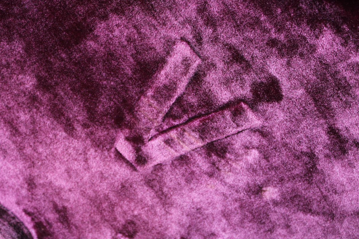 Close-up of the case's pink interior, showing two fabric straps forming a V-shape, with some discoloration and wear.