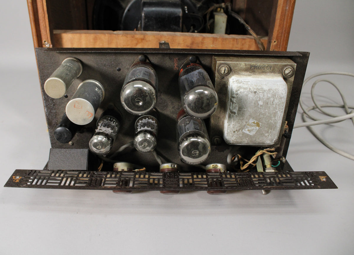 Top-down view of the amp's chassis, revealing multiple vacuum tubes, a large metal transformer, and a perforated brown control panel.