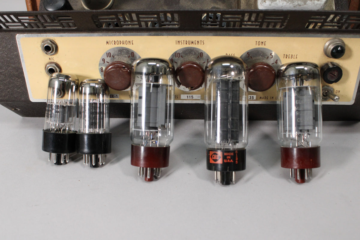 Close-up of the amp's top panel, showing five vacuum tubes, four brown Bakelite knobs, and two input jacks.
